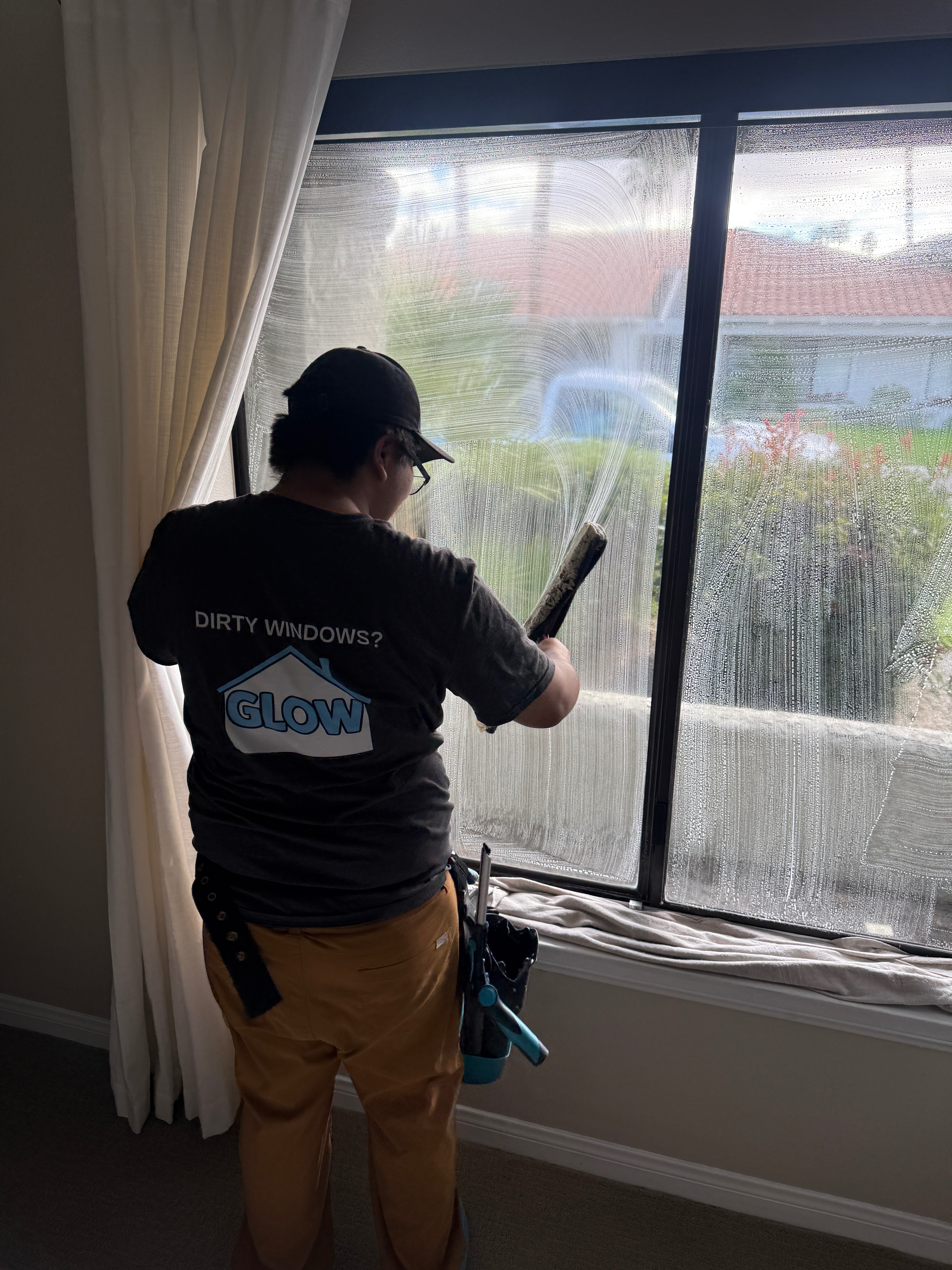 Professional window cleaning with a squeegee at a Palm Desert home